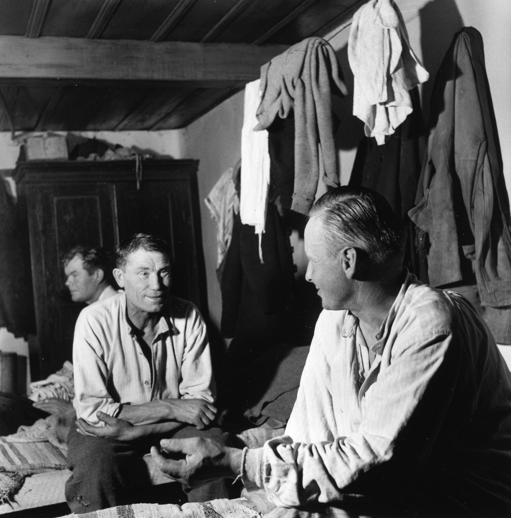 Miehet tarinoimassa saunan jälkeen majoitusparakissa